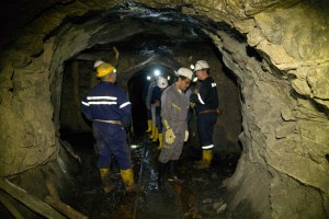 Inside a Colombian mine. Tim Moore (far right) discusses with colleagues the geology of the mine.